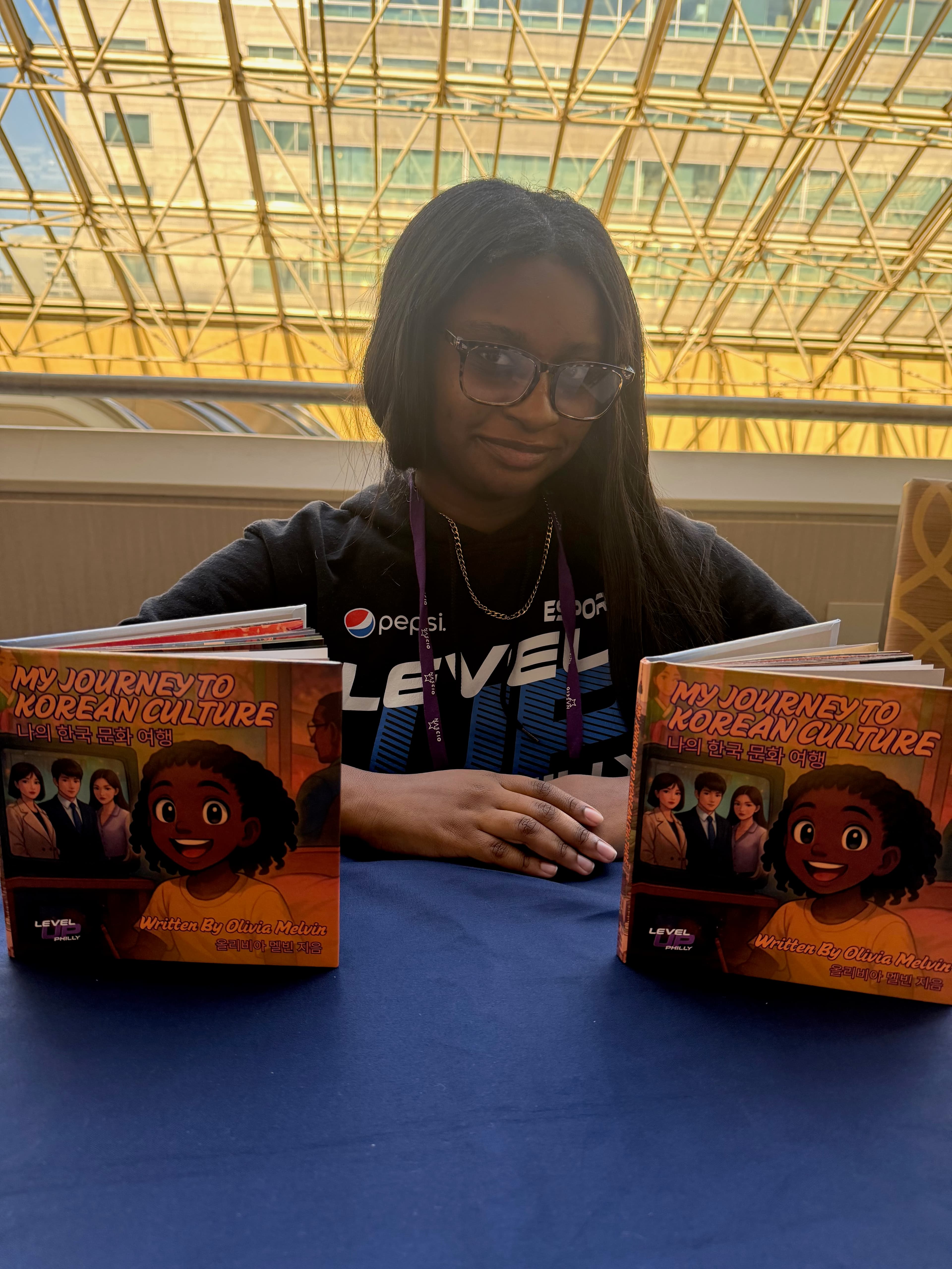 Photo of Olivia holding copies of My Journey to Korean Culture